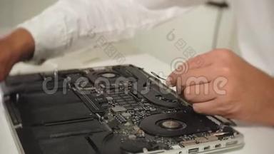 一个人<strong>正在修理</strong>笔记本电脑。 计算机修复的概念.. 用一个人<strong>修理</strong>笔记本电脑主板